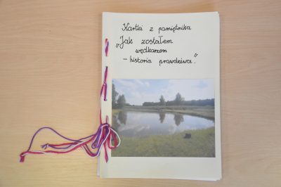 Zdjęcie pracy konkursowej, książeczka zszyta kolorowym sznurkiem, zdjęcie jeziora