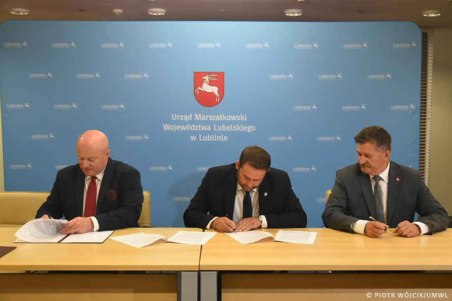 Marszałek Stawiarski (z lewej), jeden z beneficjentów (po środku) członek zarządu Szwed (z prawej) w trakcie podpisywania umowy