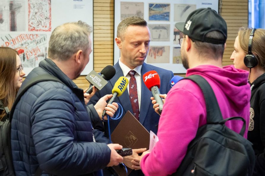 Wicemarszałek WL w otoczeniu dziennikarzy, udziela wywiadu