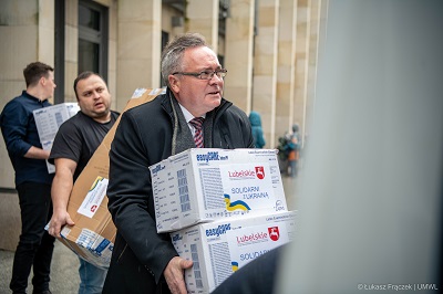 Wicemarszałek WL zanosi do karetki paczki pomocowe dla Ukrainy