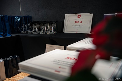Widok na ułożone na stole dyplomy i puchary dla laureatów konkursu Ekorolnik