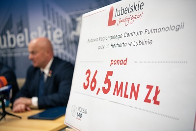 Tablica z napisaną kwotą 36,5 mln zło, w tle marszałek Jarosław Stawiarski