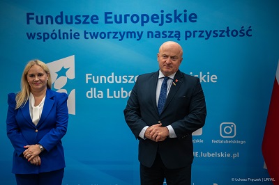 Dyrektor Anna Brzyska i Marszałek Jarosław Stawiarski stoją wspólnie na tle ścianki z napisem Fundusze Europejskie wspólnie tworzymy naszą przyszłość