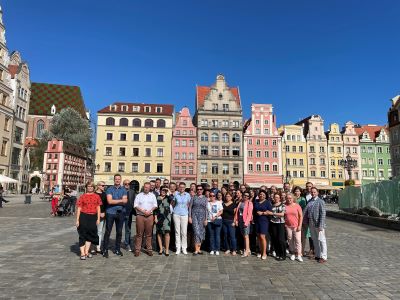 Grupa kilkudziesięciu osób pozuje do zdjęcia na wrocławskiej Starówce