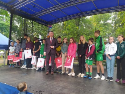 Laureaci konkursu stoją z nagrodami na podium w Parku w centrum Firleja w towarzystwie Wójta Gminy Firlej.