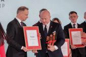 Prezydent Andrzej Duda wręcza dyplom Marszałkowi Jarosławowi Stawiarskiemu. Marszałek trzyma w jednej ręce otrzymaną wcześniej statuetkę