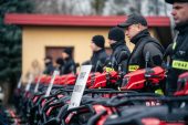 Ujęcie profilowe ustawionych quadów i stojących przy nich strażaków