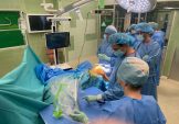 Trzech chirurgó stoi w sali operacyjnej podczas wykonywania zabiegu