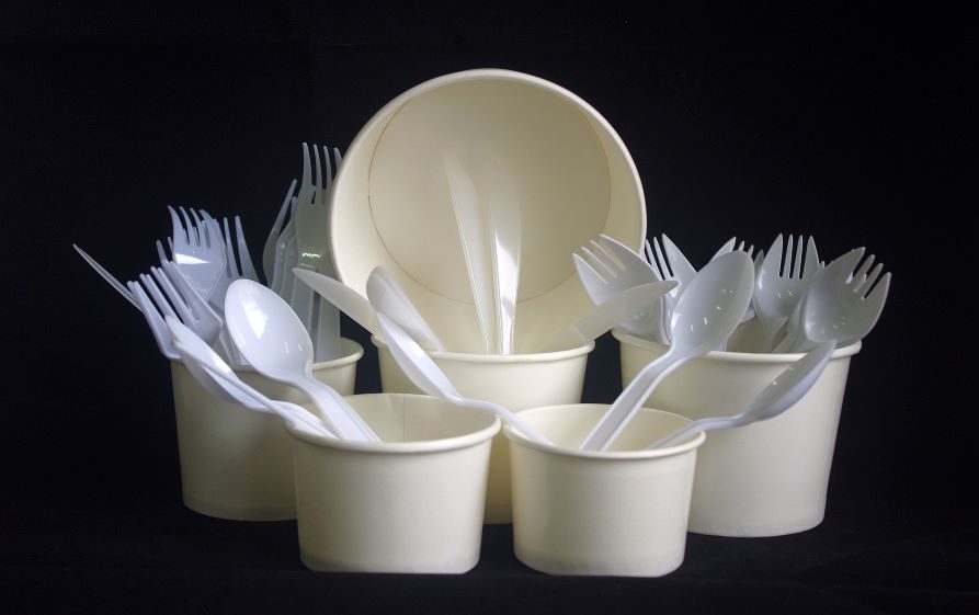 Plastikowe naczynia, w tym kubki, miski i sztućce zgromadzone w jednym miejscu