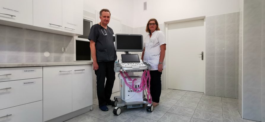 Dwójka lekarzy stoi przy nowoczesnym aparacie do USG