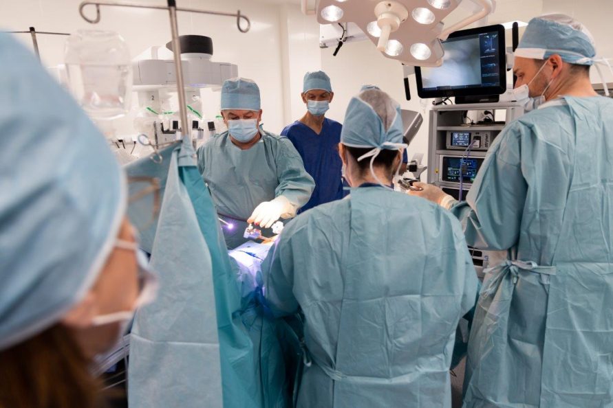 Kilku lekarzy chirurgów w fartuchach podczas operacji