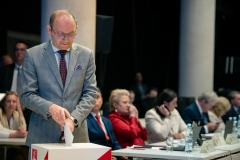 Radny Radosław Brzózka wrzuca kartę z zaznaczonym głosem do urny wyborczej