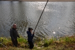 mężczyzna oraz chłopiec łowiący ryby na brzegu rzeki