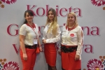 Gala finałowa konkursu Kobieta Gospodarna Wyjątkowa. trzy uczestniczki w białoczerwonych strojach na tle ścianki z napisem tytułu konkursu.