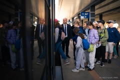 Wicemarszałek Piotr Breś przepuszcza młodzież szkolną wsiadająca do autobusu lotniczego
