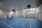 Widok na dużą salę gimnastyczną z bramkami i miejscem do gry w piłkę