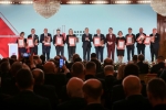 Na scenie stoją wszyscy laureaci nagrody gospodarczej w towarzystwie Prezydenta Andrzeja Dudy. Łącznie na scenie znajduje się około piętnastu osób