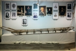 Widok na wystawę zdjęć z muzeum oraz drewnianych sani polarnych