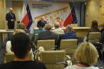 przy stole prezydialnym w tle zdjęcia Marszałek Jarosław Stawiarski i zastępca dyrektora ROPS Marta Drozd. na sali siedzą beneficjenci programu