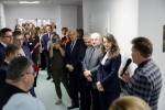 Marszałek Jarosław Stawiarski stoi na korytarzu szpitala w towarzystwie około dwudziestu innych osób  i przysłuchuje się wypowiedzi mężczyzny, który stoi na przodzie i mówi do mikrofonu