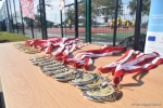 Mecz w ramach akcji "z podwórka na boisko". Pamiątkowe medale z biało-czerwonymi wstęgami leżące na stole. W tle nowe boisko.