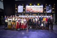 Na scenie, wraz z Członkiem Zarządu Marcinem Szewczakiem, do zdjęcia pozuje liczna grupa ludzi. Wśród nich, znaczna większość przyodziana jest w tradycyjny strój w całości lub częściowo. Sześć osób z tej grupy trzyma w rękach dyplomy oraz wyróżnienia.