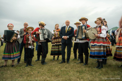 Marszałek Województwa Lubelskiego Jarosław Stawiarski wśród grających na instrumentach ludzi ubranych w stylu ludowym. 