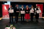 Sześć osób stoi na scenie i pozuje do zdjęcia wspólnie z członkiem zarządu województwa lubelskiego i dyrektorem urzędu. Laureaci prezentują otrzymane dyplomy