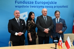 Marszałek Jarosław Stawiarski i wicemarszałek Piotr Breś pozują wspólnie do zdjęcia  z beneficjentami programu funduszy unijnych