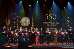 Przedstawiciele  instytucji, które otrzymały medal 550-lecia stoją wspólnie na scenie i pozują do zdjęcia wraz z członkami zarządu województwa lubelskiego