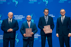 Marszałek Jarosław Stawiarski, były Prezydent Andrzej Duda oraz przedstawiciele dwóch regionów przystępujących do Sieci Regionów Trójmorza pozuje na scenie podczas Kongresu. 