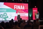 Scena na której stoi dyrektorka UMWL oraz dwoje konferansjerów, w tle na ekranie wyświetla się grafika do wydarzenia