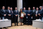 10 osób ustawionych do zdjęcia, na środku kobieta trzymająca pamiątkowy dyplom