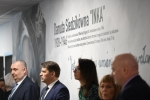 Kilka osób stoi pod muralem z  podobizną Danutu Siedzikówny ps. Inka. Mural znajduje się we wnętrzu budynku szkoły.