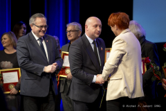 Wicemarszałek Piotr Breś i Radny Sejmiku Zbigniew Wojciechowski wręczają laureatce odznaczenie