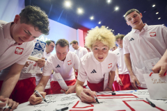 Młodzi sportowcy z reprezentacji Polski podpisują koszulki