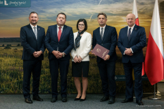 Odbiorcy umowy pozują do zdjęcia wraz z marszałkiem Stawiarskim oraz wicemarszałkiem Wojciechowskim.