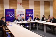 Członkowie Prezydium WRDS WL siedzą przy połączonych stołach w kształcie litery U podczas posiedzenia.