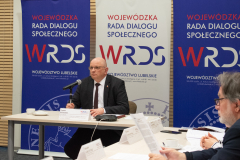 Przewodniczący Tomasz Pitucha siedzi przy stole podczas posiedzenia