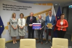 Przekazanie czeków na realizację działań związanych z przeciwdziałaniem skutkom rozprzestrzeniania się pandemii Covid-19 w domach pomocy społecznej. Od lewej: Ewa Nowak Dyrektor PCPR w Kraśniku, Iwona Szymańska skarbnik powiatu, marszałek Jarosław Stawiarski, Andrzej Rolla starosta kraśnicki trzyma czek z wypisaną kwotą dofinansowania, Andrzej Cieśla wicestarosta trzy,a teczkę z podpisaną umową, zastępca dyrektora ROPS Lublin Marta Drozd