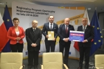 Przekazanie czeków na realizację działań związanych z przeciwdziałaniem skutkom rozprzestrzeniania się pandemii Covid-19 w domach pomocy społecznej. Od lewej: zastępca dyrktora ROPS w Lublinie Marta Drozd, Marek Seroka skarbnik powiatu, Witold Marucha wicestarosta trzyma teczkę z podpisaną umową, marszałek Jarosław Stawiarski, Stanisław Grześko starosta zamojski trzyma czek z wypisaną kwotą dofinansowania