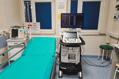 Zdjęcie przedstawiające łóżko w szpitalu i stojącą obok niego maszynę. 