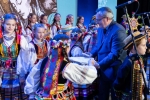 Wicemarszałek Zbigniew Wojciechowski stoi wśród dzieci z ludowego zespołu