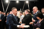 Wicemarszałek Michał Mulawa trzyma w ręku koszyczek w kótrym znajduje się oplatek. Idzie do zebranych rozdać opłatek. Dookoła niego znajduje się około kilkunastu osób