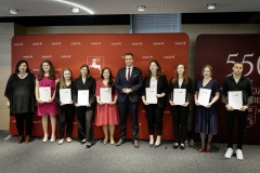 Członek Zarządu WL Marcin Szewczak pozuje do wspólnego zdjęcia ze stypendystami. Wszyscy stoją w sali konferencyjnej za nimi znajduje się ścianka lubelskie smakuj życie i 550 lecie województwa lubelskiego