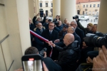 Marszałek Jarosław Stawiarski wspólnie z Prezydentem Miasta Lublin ściąga biało czerwoną wstążkę z tablicy pamiątkowej . Wokół nich znajduje się około kilkunastu innych osób przyglądających się odsłonięciu