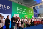 na scenie polagra grupa osób trzymających nagrody i dyplomy