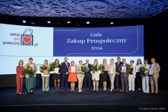 Na scenie pozuje do zdjęcia około 20 laureatów  certyfikatu, za nimi na dużym ekranie wyświetla się napis Gala Zakup Prospołeczny 2024