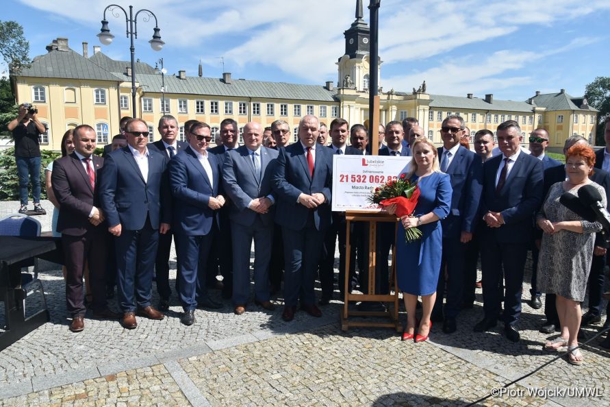 Grupowe zdjęcie po podpisaniu umowy na rewitalizację Zespołu Pałacowego Potockich w Radzyniu Podlaskim. W tle Pałac Potockich.