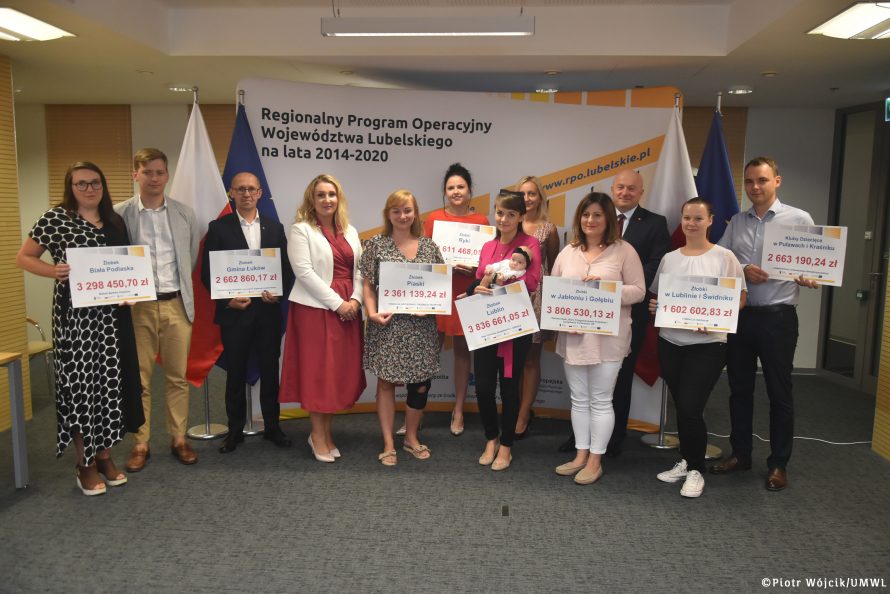 Grupowe zdjęcie beneficjentów projektu dofinansowania powstawania żłobków w województwie lubelskim z dyrektor departamentu Wdrażania Europejskiego Funduszu Społecznego Katarzyną Tokarczuk i Marszałkiem Jarosławem Stawiarskim